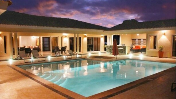 A hotel with a large indoor swimming pool, lounge chairs, and a bar area. - Villa With Jacuzzi, TVs in all Bedrooms (Sosúa)
