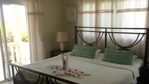 A bed with a metal frame, two pillows, and a towel with a floral design. - Villa in Gated Community Furnished Lots Amenities (Sosúa)
