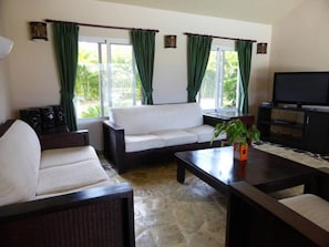 A living room with a sofa, coffee table, and television.