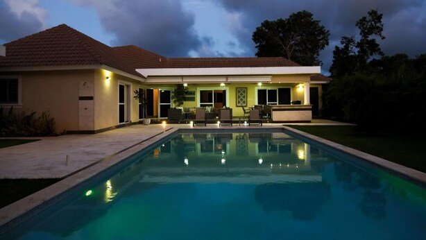 A house with a swimming pool, outdoor furniture, and a patio area. - Villa Equipped With an Infinity Edged Pool in Gated Community (Sosúa)