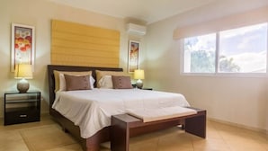 Una camera da letto con un letto grande, due comodini, una finestra e opere d'arte alle pareti.