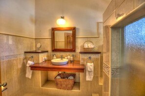 A bathroom with a large mirror, a sink, and a towel rack. - Villa Jardin Paraiso Cabarete Villa Near the Beach (Cabarete)