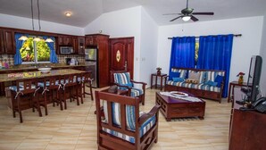 A spacious living area with a kitchen, dining set, and a sofa set. - Sunny Days and Tropical Nights Await you (Sosúa)