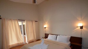 Ein Hotelzimmer mit Bett, Vorhängen und zwei Wandleuchten.