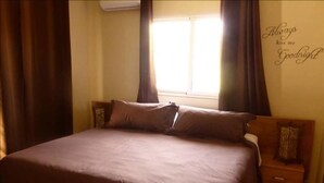 Un dormitorio con una cama grande, una mesita de noche y una pared con un mensaje.