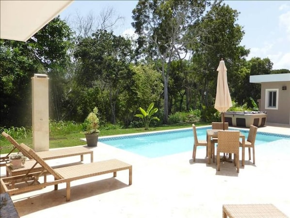 Relax by the pool surrounded by lush greenery and modern architecture.