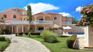A large, multi-story building with a central courtyard, a swimming pool, and a well-maintained garden. - Private 6 Bedroom Villa Great for Parties (Sosúa)