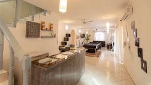 A modern living room with a pool table, a sofa, and a staircase. - Private 6 Bedroom Villa Great for Parties (Sosúa)