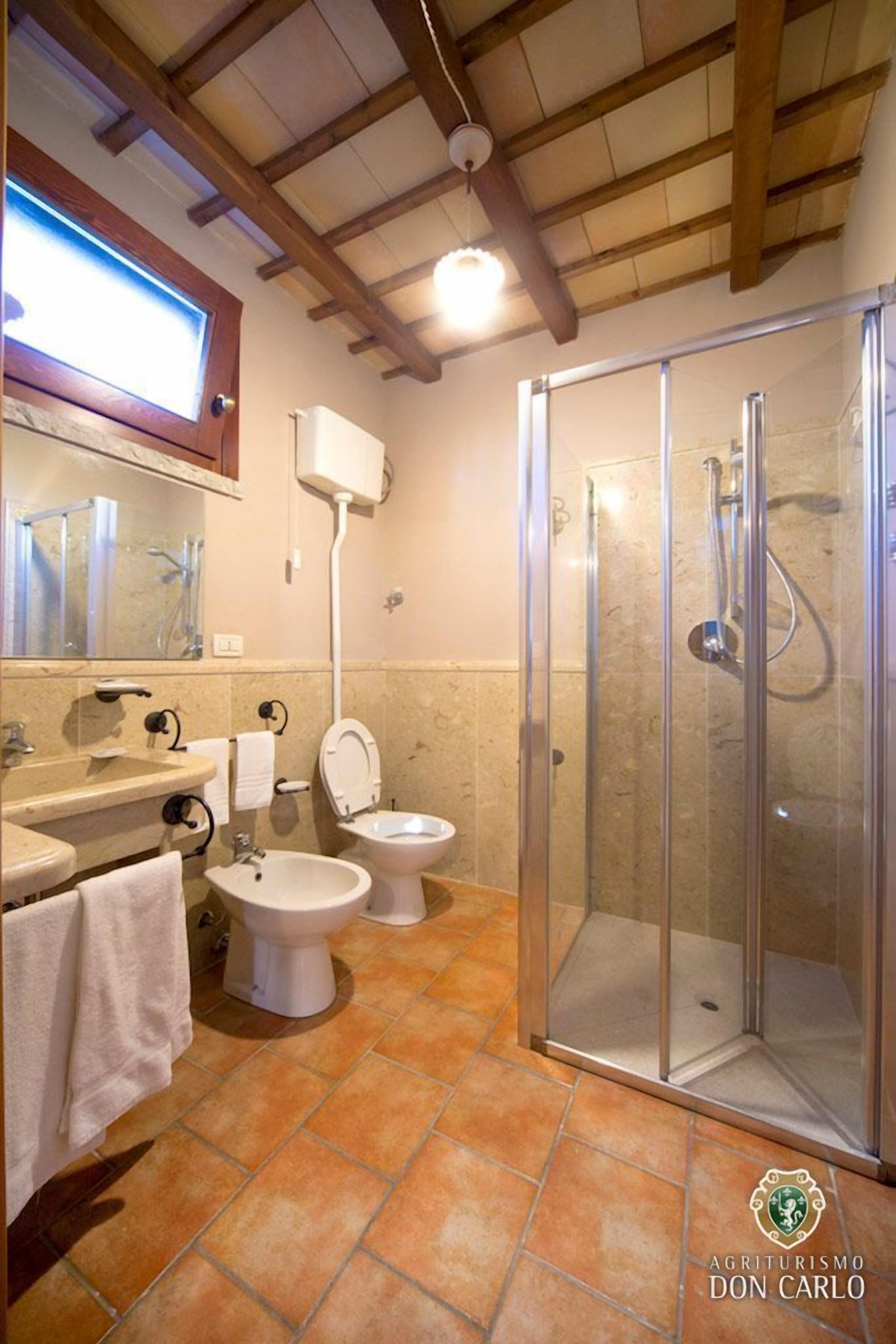 Une salle de bain avec douche, toilettes et lavabo.