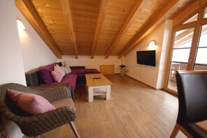 Relax in a warm and inviting living space with a comfortable seating area, sofa, chairs, and flat-screen TV.