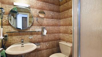 Un baño con lavamanos, inodoro y espejo.