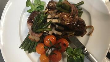 Un piatto di cibo con carne, fagiolini e pomodorini.