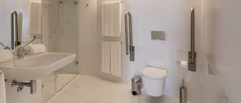 Une salle de bain moderne équipée d’un lavabo, de toilettes et d’une zone douche.