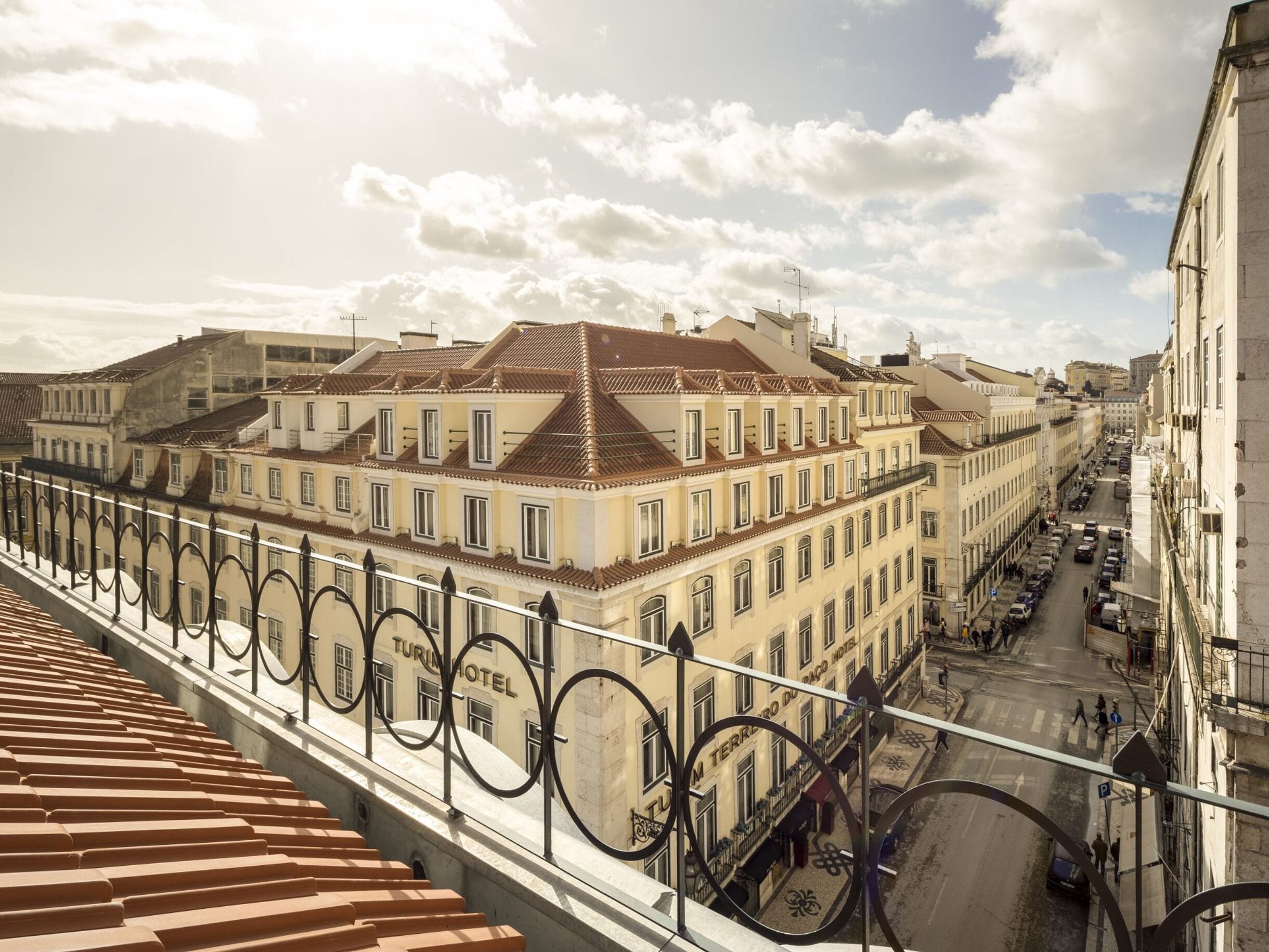 Un hôtel doté d’un toit recouvert de tuiles, de nombreuses fenêtres et d’un balcon avec une rambarde en métal.