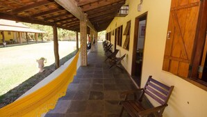 Un espacio al aire libre techado con bancos y una hamaca.
