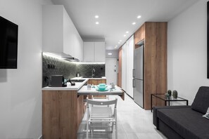 Une cuisine moderne avec un coin repas, des éléments décoratifs en bois et un téléviseur encastré.
