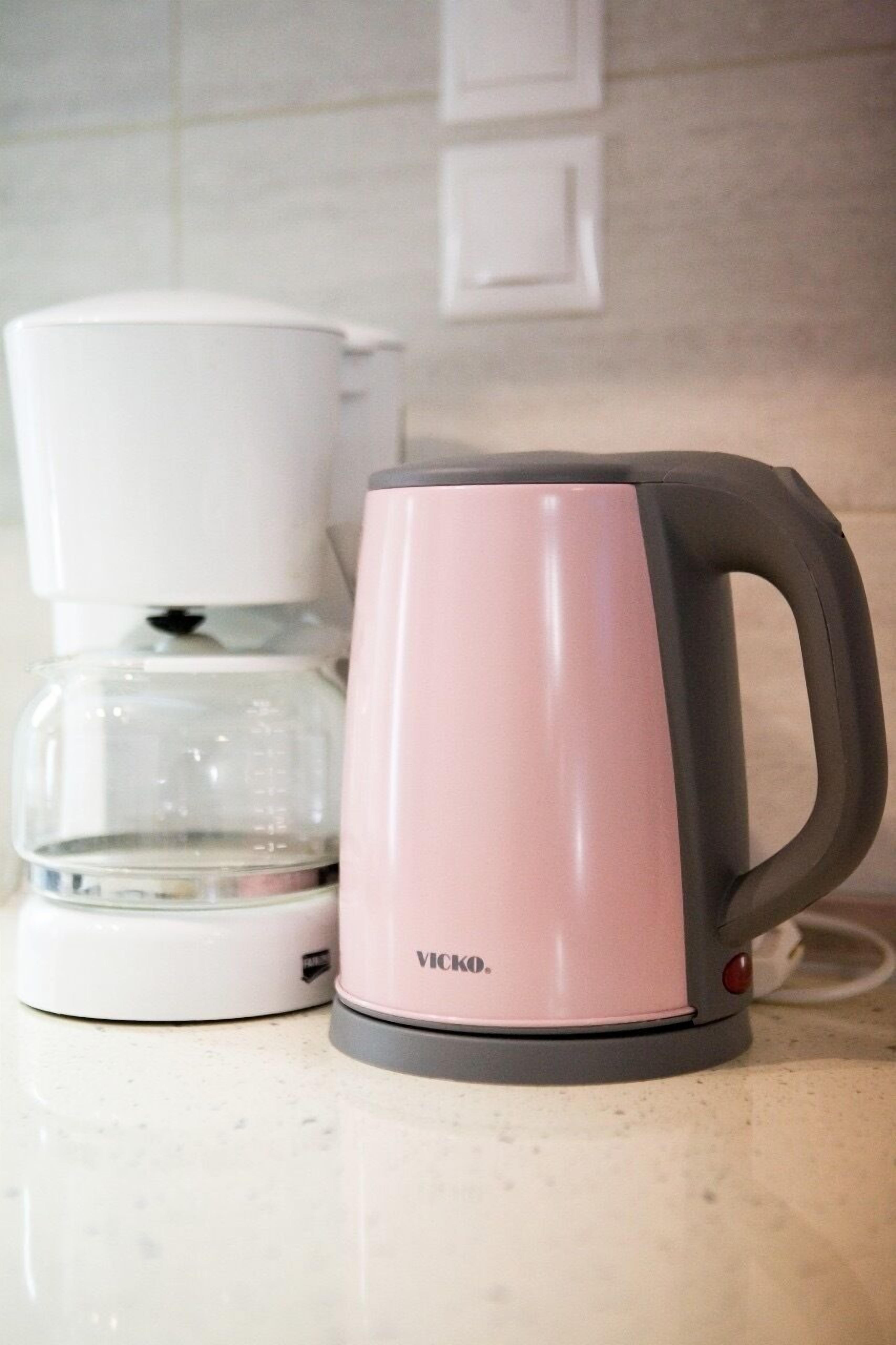 A pink and white coffee maker on a kitchen counter.