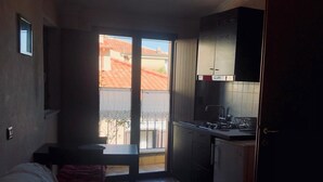 Een knus woongedeelte met een kitchenette, een eethoek en een slaapbank.
