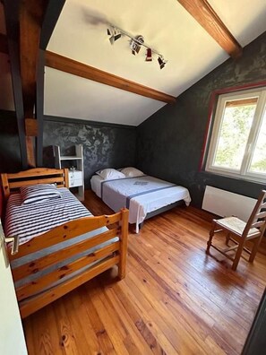 A room with a bunk bed, a single bed, a chair, and a window. - Chambres des Arrys (Bas-en-Basset)