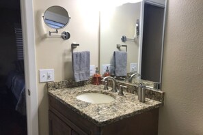 Een bad/douchecombinatie, een haardroger, handdoeken, zeep