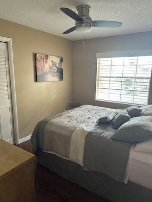 A bedroom with a bed, a ceiling fan, a window with blinds, and a painting on the wall. -  3/ 2 kid friendly home, only minutes to Legoland. (Winter Haven)