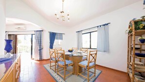 Un espace repas comprenant une table ronde, des chaises et un buffet.