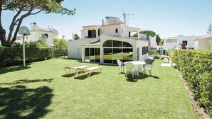 Une villa dotée d’un patio ensoleillé, d’une piscine et d’un espace extérieur aménagé et abrité.