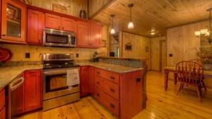 Una cucina con mobili in legno, un piano cottura in acciaio inossidabile e un forno a microonde.
