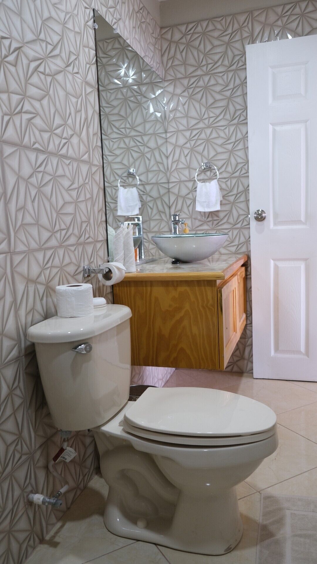 A bathroom with a toilet, a sink, and a mirror.