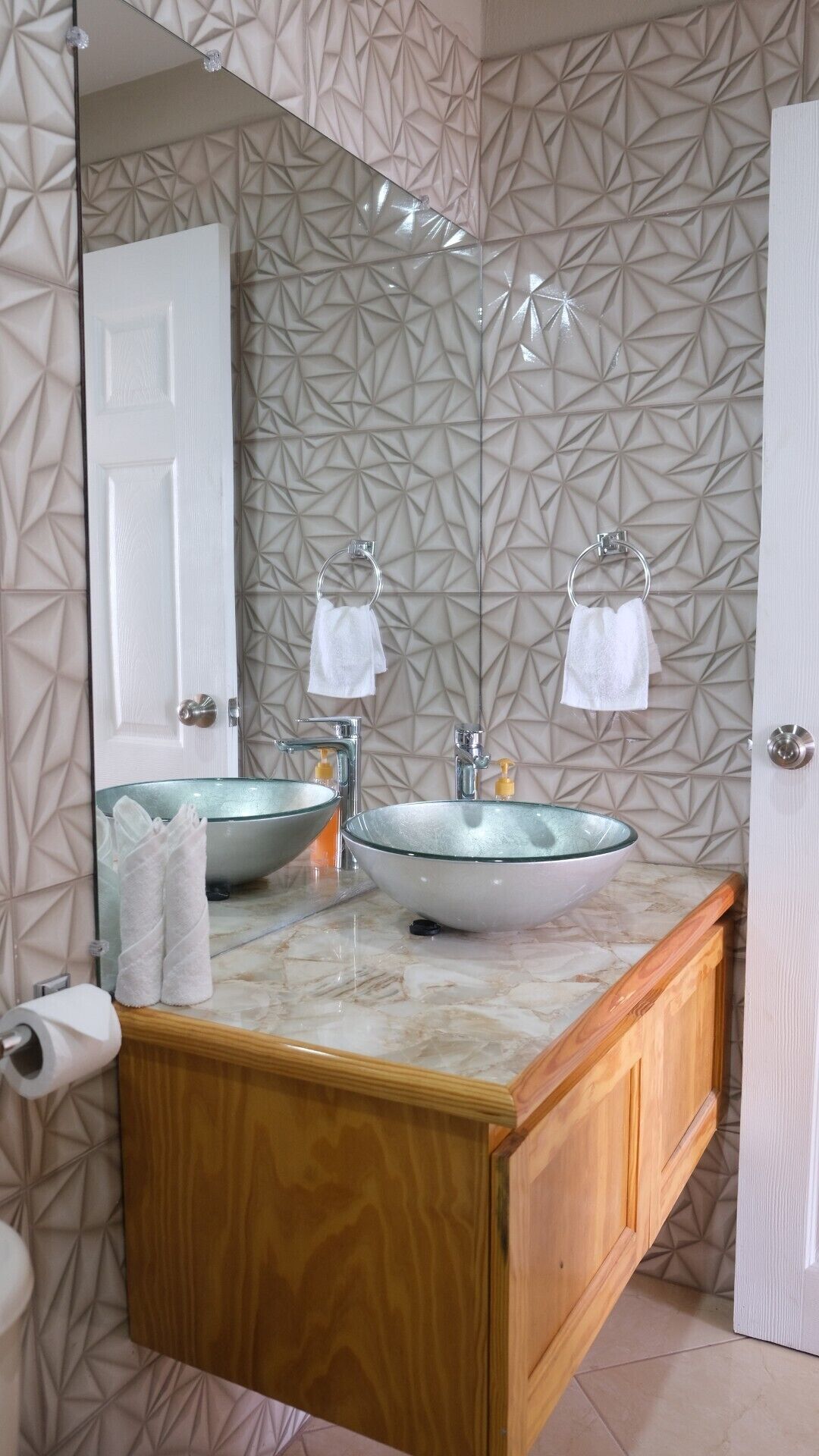 Un baño con lavamanos doble, un espejo grande y un mueble de tocador de madera.