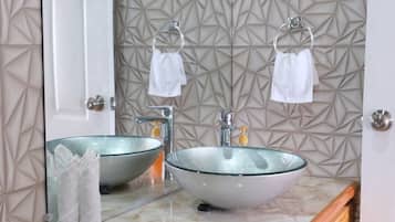 Un baño con lavamanos doble, un espejo grande y un mueble de tocador de madera.