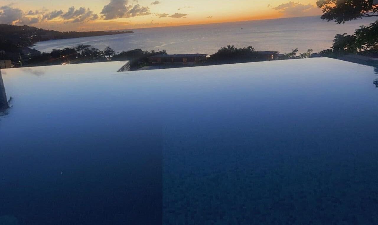 Une piscine à débordement offrant une vue sur l’océan et un magnifique coucher de soleil.
