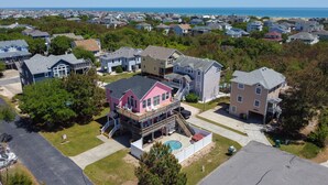 Un quartier résidentiel avec des maisons, une piscine et une plage en arrière-plan.