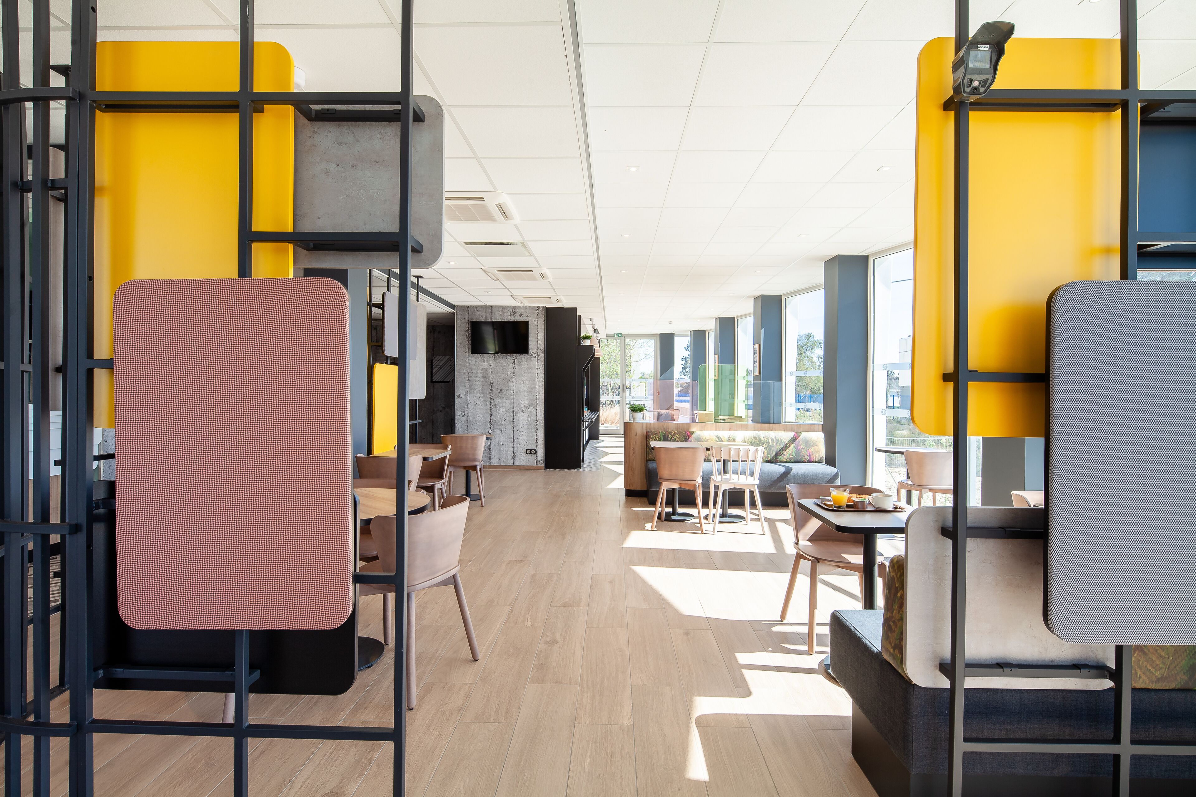 Un intérieur moderne avec des espaces de détente, une cuisine ouverte et de grandes fenêtres qui laissent entrer la lumière naturelle.