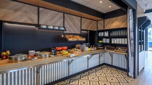 Una mesa de buffet con diferentes platos y utensilios.