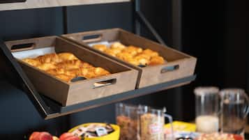 Una barra de petit esmorzar amb dos calaixos de fusta que contenen croissants.