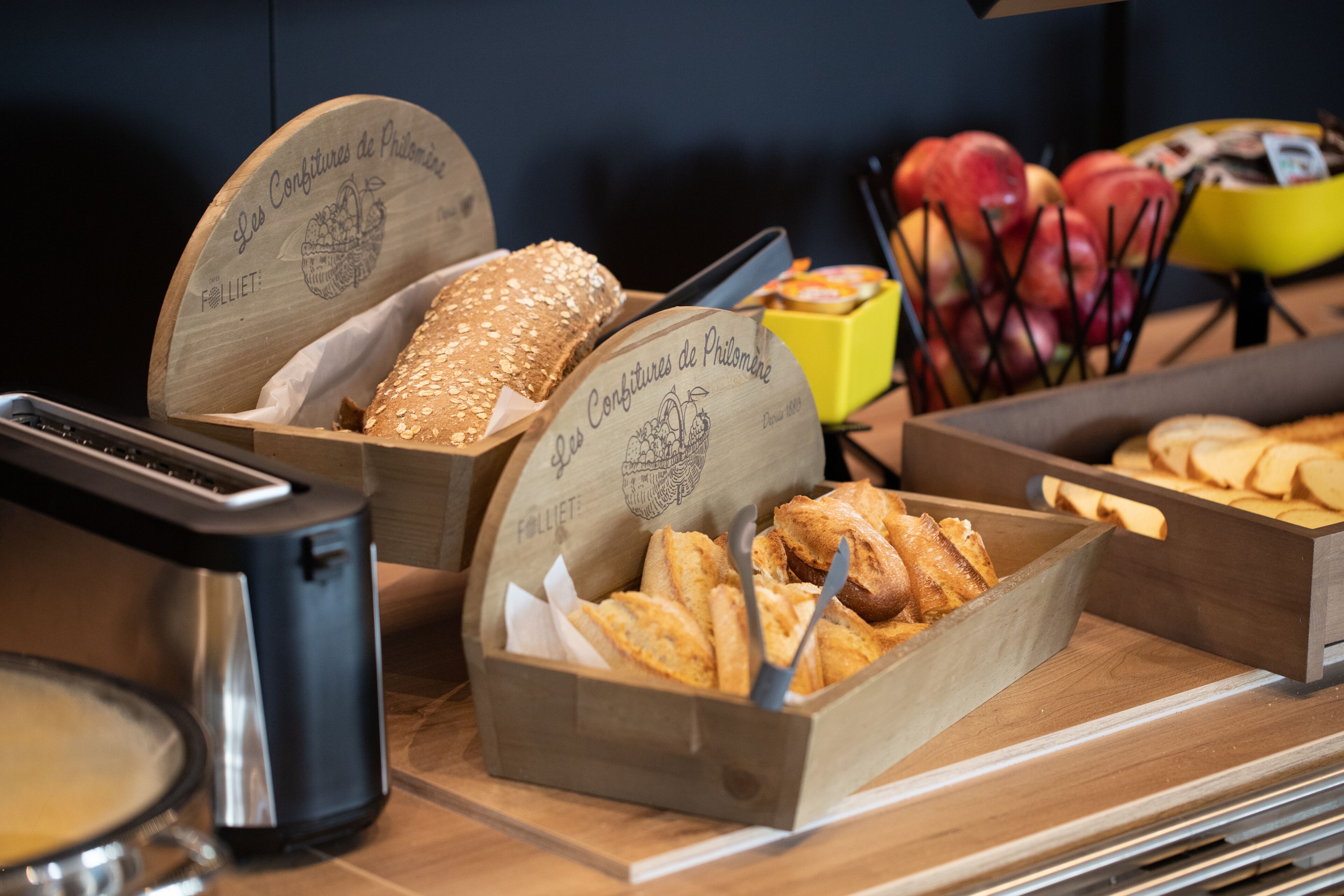 Un bufé con diversas opciones de comida, como pan, pasteles y frutas.