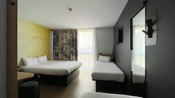 A hotel room with two beds, a desk, a chair, a mirror, and a window with curtains.