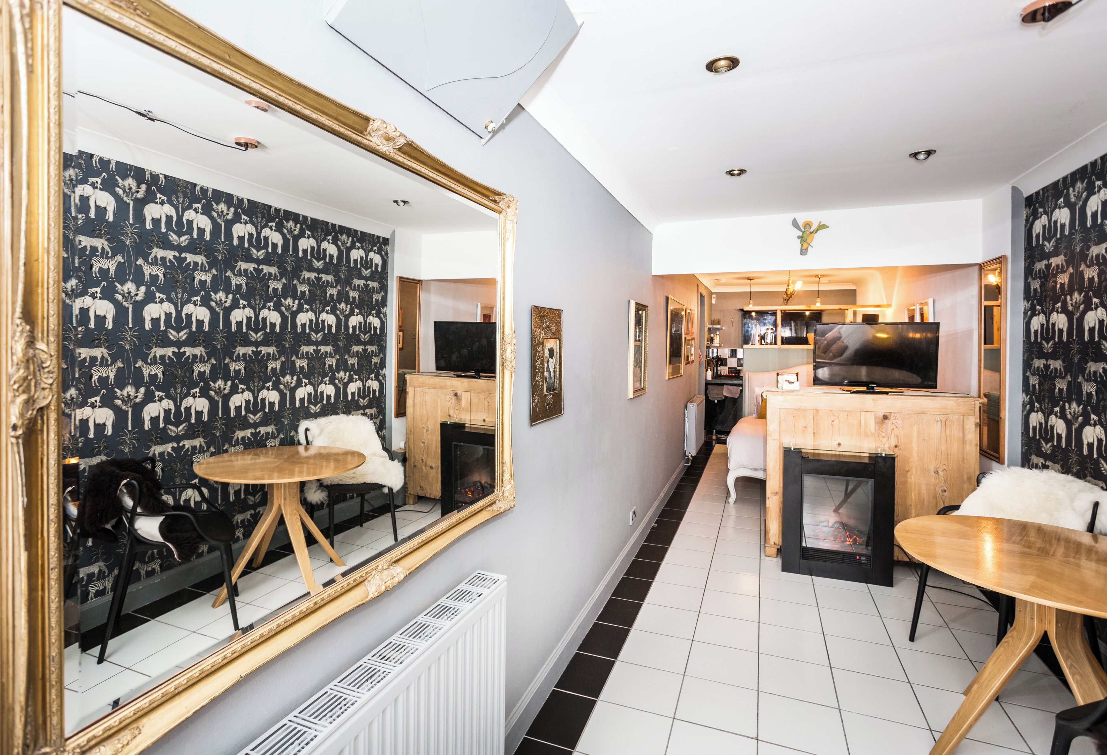 Un salon moderne avec une cheminée, un coin repas et une cuisine en arrière-plan.