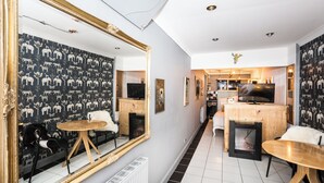 Ein modernes Wohnzimmer mit Kamin, einem Essbereich und einer Küche im Hintergrund.