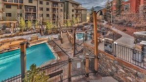A multi-story hotel with outdoor swimming pools, a covered patio area, and a view of mountains. - Large 4 Bedroom Ski-in/Out, Sleeps 12, Vaulted Ceilings, Pool, Hot Tub MC12B (Park City)