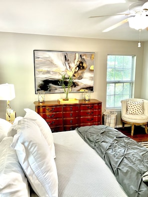 A bedroom with a bed, dresser, chair, artwork, and a window. - Your Annapolis Adventure Starts Here!! (Annapolis)
