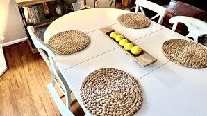 A dining area with a round table, white chairs, woven placemats, and a tray with lemons. - Your Annapolis Adventure Starts Here!!  (Annapolis)