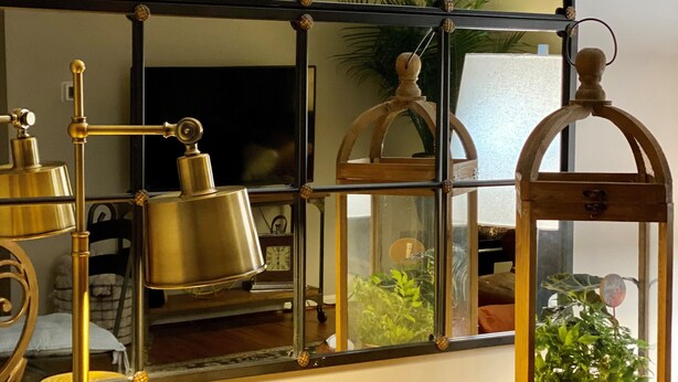 A wooden table with a brass lamp, two brass cups, and a glass enclosure with a plant. - Your Annapolis Adventure Starts Here!!  (Annapolis)