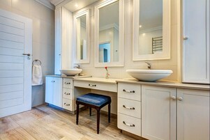 Un baño moderno con dos lavamanos, un tocador y un espejo.