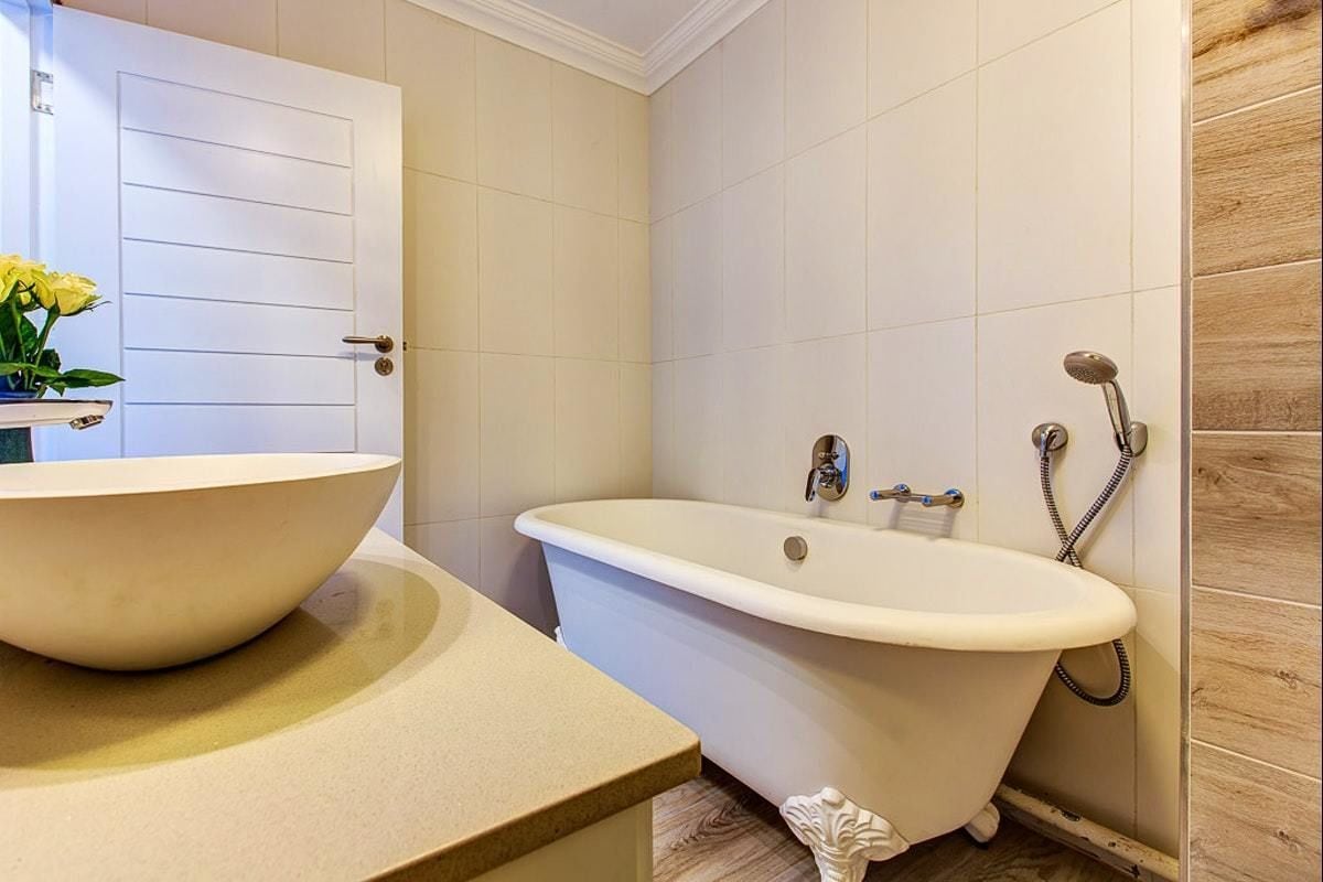 A bathroom with a freestanding bathtub, a sink with a bowl, and a shower area.