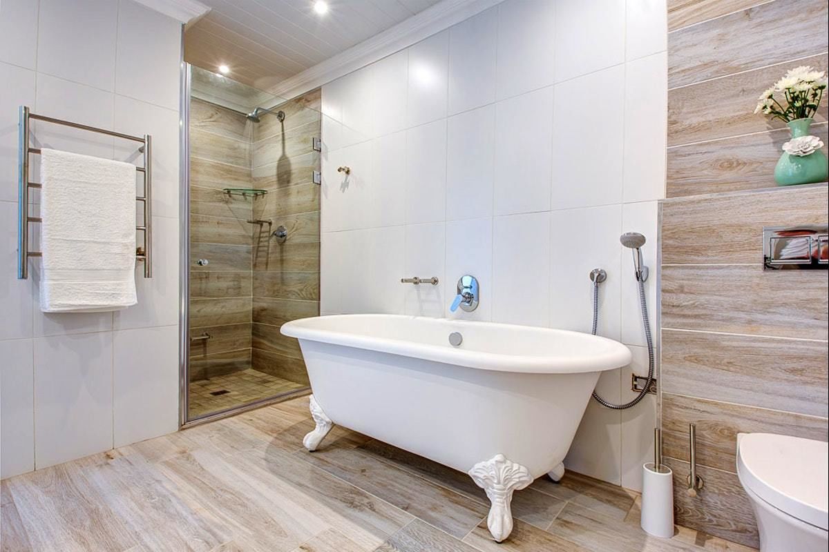 A modern bathroom with a freestanding bathtub, a glass-enclosed shower, and a toilet.