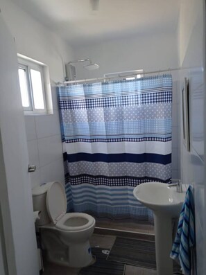 Een douche, handdoeken, toiletpapier