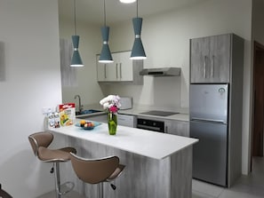 Enjoy cooking in this well-equipped kitchen with a central island, oven, and stainless steel appliances.