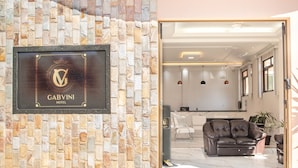 A hotel entrance with a stone wall and a framed sign reading "GABVINI HOTEL". - Gabvini Hotel (Lima Duarte)